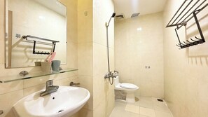 Ein Badezimmer mit einem weißen Waschbecken, einer Glasablage, einem Spiegel, einer Dusche und einer Toilette.