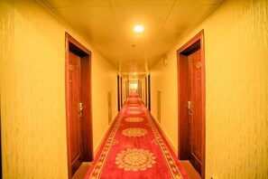 A hotel hallway with a carpeted floor and doors on both sides. - Fuli Zonghe Service Center (Beihai)