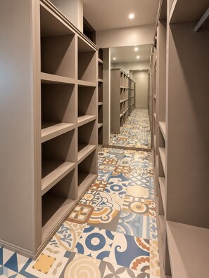 A hallway with patterned floor tiles and built-in shelving units.
