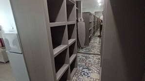 A hallway with patterned floor tiles, a grey storage unit, and a ceiling-mounted security camera.