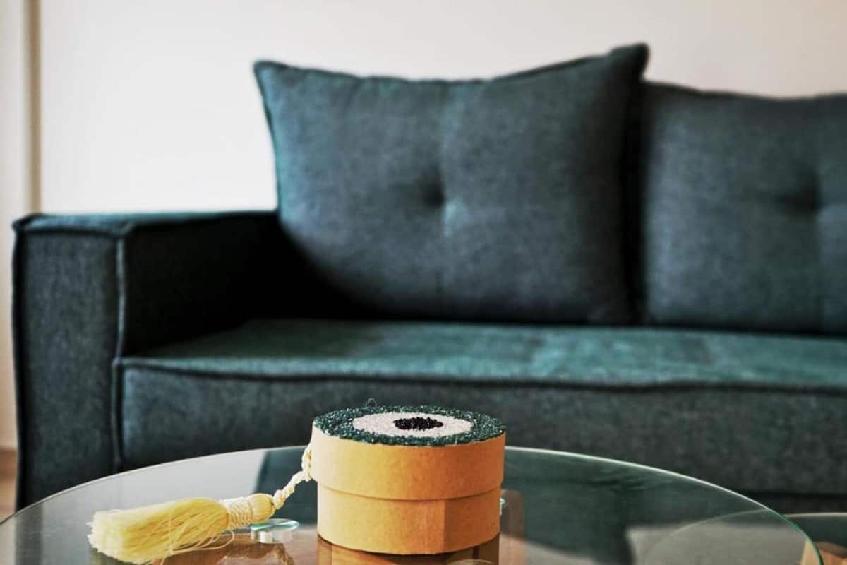 A round glass table with a decorative box and a yellow tassel.