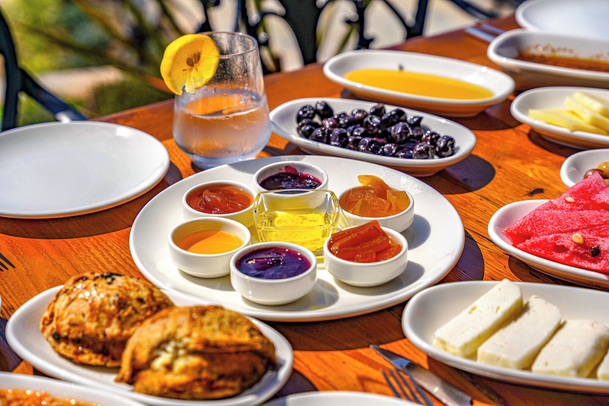 A table set with various breakfast items including fruits, pastries, and beverages.