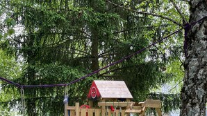 A playground with a wooden play structure, including a slide and a swing set. - Hôtel Gex (Gex)