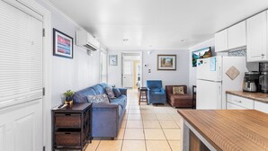 A compact living space with a kitchenette, a sofa, a coffee table, and a chair. - Cozy 1 bedroom condo, Downtown, with a pool, close to the beach and the famous OC boardwalk (Ocean City)