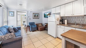 A compact living space with a kitchenette, a sofa, a chair, and a dining table. - Cozy 1 bedroom condo, Downtown, with a pool, close to the beach and the famous OC boardwalk (Ocean City)