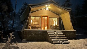A snow-covered outdoor area with a tent structure, a wooden door, and a staircase leading up to the entrance. - The Tiger Nest Camp (Paro)