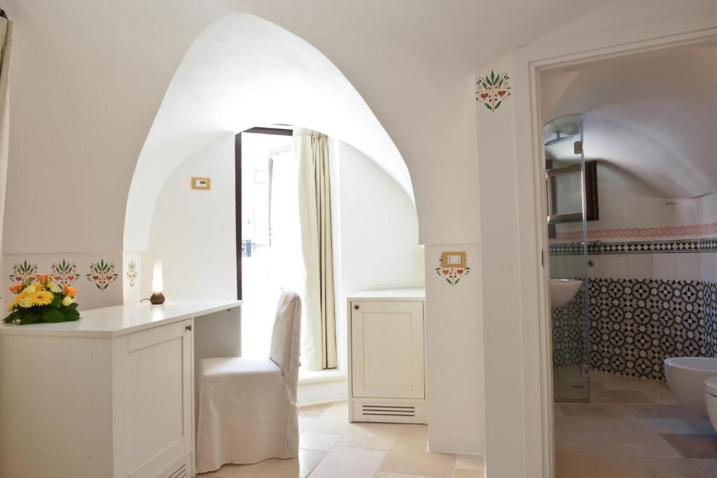 A bathroom with a shower, a sink, and a toilet. There is a towel hanging on the wall.