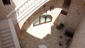 A stone courtyard with a staircase, a small table, and potted plants. - Dimora dell'Osanna  (Carovigno)