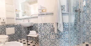 A bathroom with a white sink, a mirror, and a shower area.