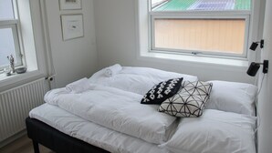 A bedroom with a bed, a window, and a radiator. - In The Heart Of Tórshavn Nr1 (Tórshavn)