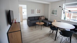 A modern living room with a sofa, a coffee table, and a dining table with chairs. - In The Heart Of Tórshavn Nr1 (Tórshavn)