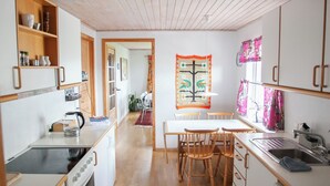 Une cuisine moderne avec un plancher en bois, des meubles blancs et un îlot central.