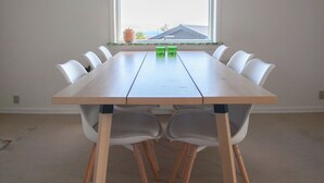 A conference room with a large table, white chairs, and a window with a view of buildings. - The Bird / Guesthouse / 10 Min Walk Downtown (Tórshavn)