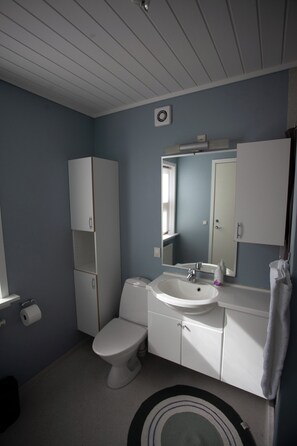 Ein Badezimmer mit Toilette, Waschbecken und Schränken.