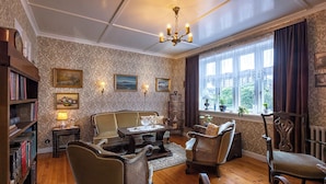A traditional room with a sofa, chairs, a table, and a bookshelf. - Downtown - Retro Decor - Stunning Views - Terrace (Tórshavn)