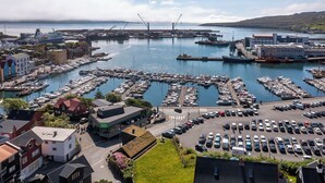 A marina with numerous boats docked, a parking area, and buildings in the foreground. - Downtown - Retro Decor - Stunning Views - Terrace (Tórshavn)