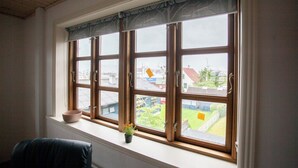 A room with a large window, a small potted plant, and a bowl on the windowsill. - Aparthotel - Marina - Central - Tórshavn (Tórshavn)