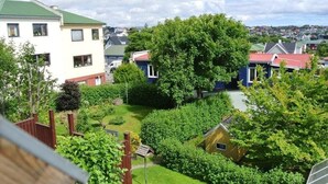 A residential area with houses, a large tree, and a well-maintained garden. - Tórshavn - Central - City & Ocean Views - 3Br (Tórshavn)