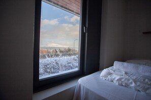 A room with a bed and a window overlooking a snowy landscape. - Large Apartment With Fabulous View Of Tórshavn (Tórshavn)