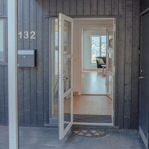 A wooden exterior with a glass door entrance, a mailbox, and a view of the interior. - Breathtaking Views - New - 220M2 - 5 Br - Walks (Argir)