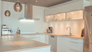 A modern kitchen with white cabinetry, a stainless steel refrigerator, a built-in oven, and a coffee maker. - Breathtaking Views - New - 220M2 - 5 Br - Walks (Argir)