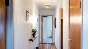A hallway with wooden flooring, white walls, and a wooden door on the right. - 3 Bedroom Apartment / Great Sea View / Quiet (Argir)
