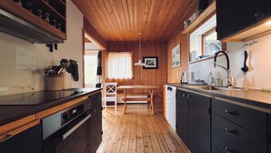 A wooden interior with a kitchen area, a bench, and a radiator. - Idyllic Vacation Home With A Breathtaking View (Bøur)