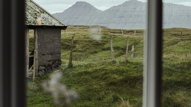 A rustic cabin with a thatched roof, surrounded by a grassy field and mountains in the background. - Authentic Cabin - Unique Location - In Nature - 2Br (Hellurnar)