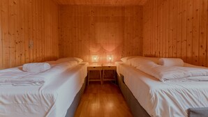 A room with two beds, wooden walls, and a wooden floor. - Unique Location - Bodanes - Hoydalar - 6 Br Villa (Hoyvík)