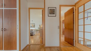 A hallway with wooden flooring and doors leading to a living area with furniture and a dining table. - Unique Location - Bodanes - Hoydalar - 6 Br Villa (Hoyvík)