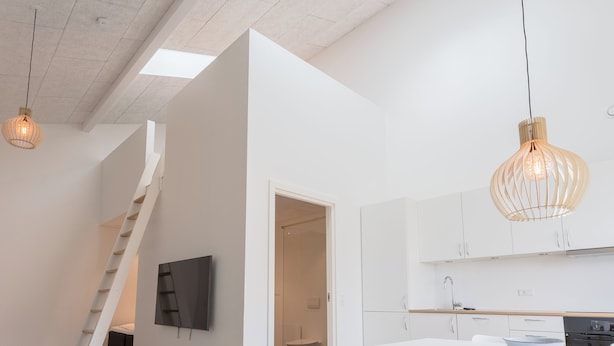 A modern interior with a staircase, a dining area, and a kitchen.