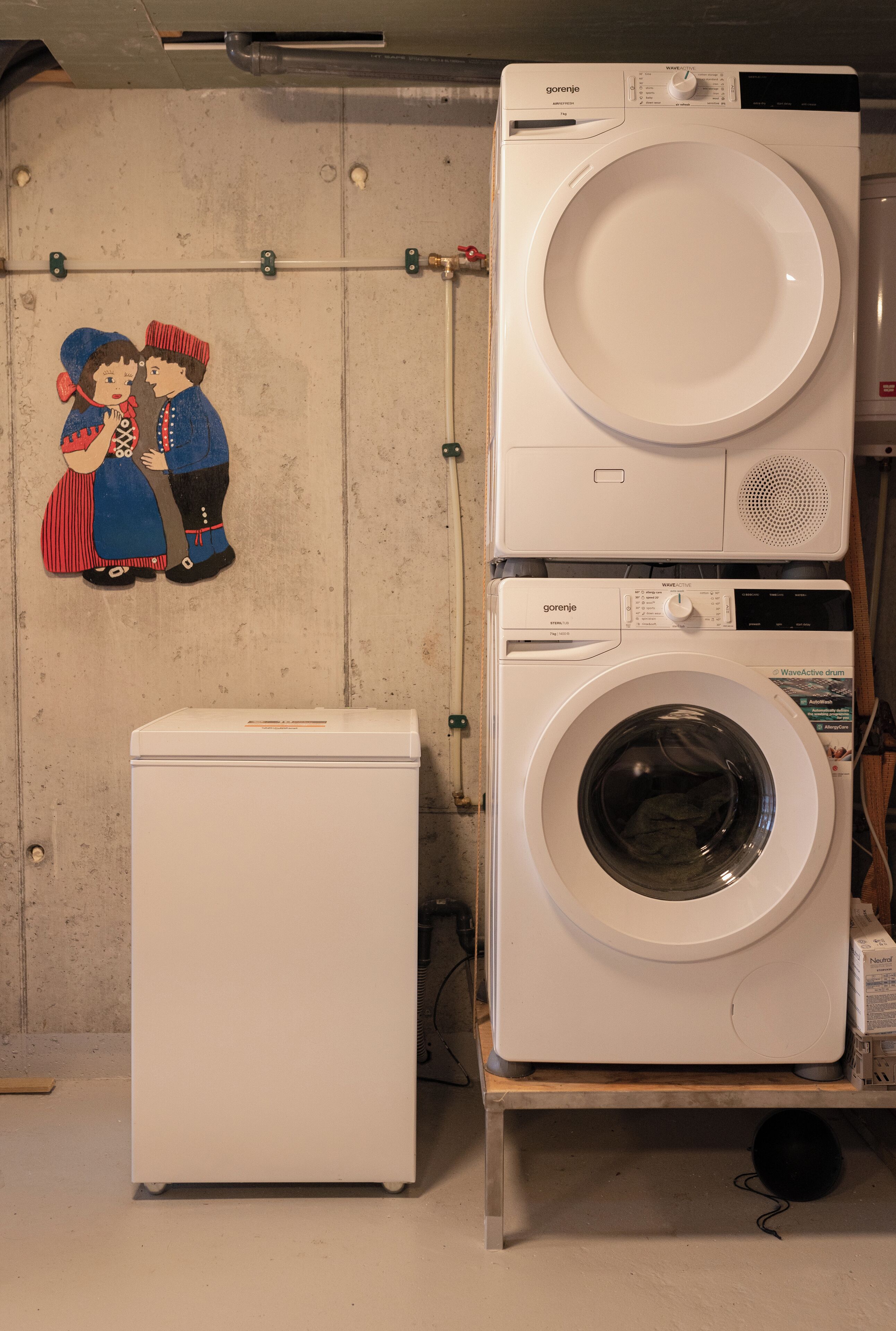Une buanderie équipée de deux machines à laver, d’un sèche-linge et d’un radiateur fixé au mur.