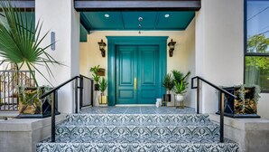 A teal door with a patterned tile entrance, potted plants, and a mailbox. - Private Suite in Historic Austin B&b: Sleeps 2! (Austin)