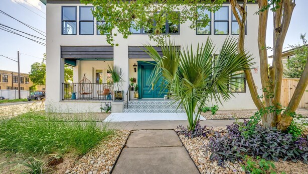 A modern two-story house with a blue door, a balcony with chairs, and a pathway leading to the entrance. - Private Suite in Historic Austin B&b: Sleeps 2! (Austin)