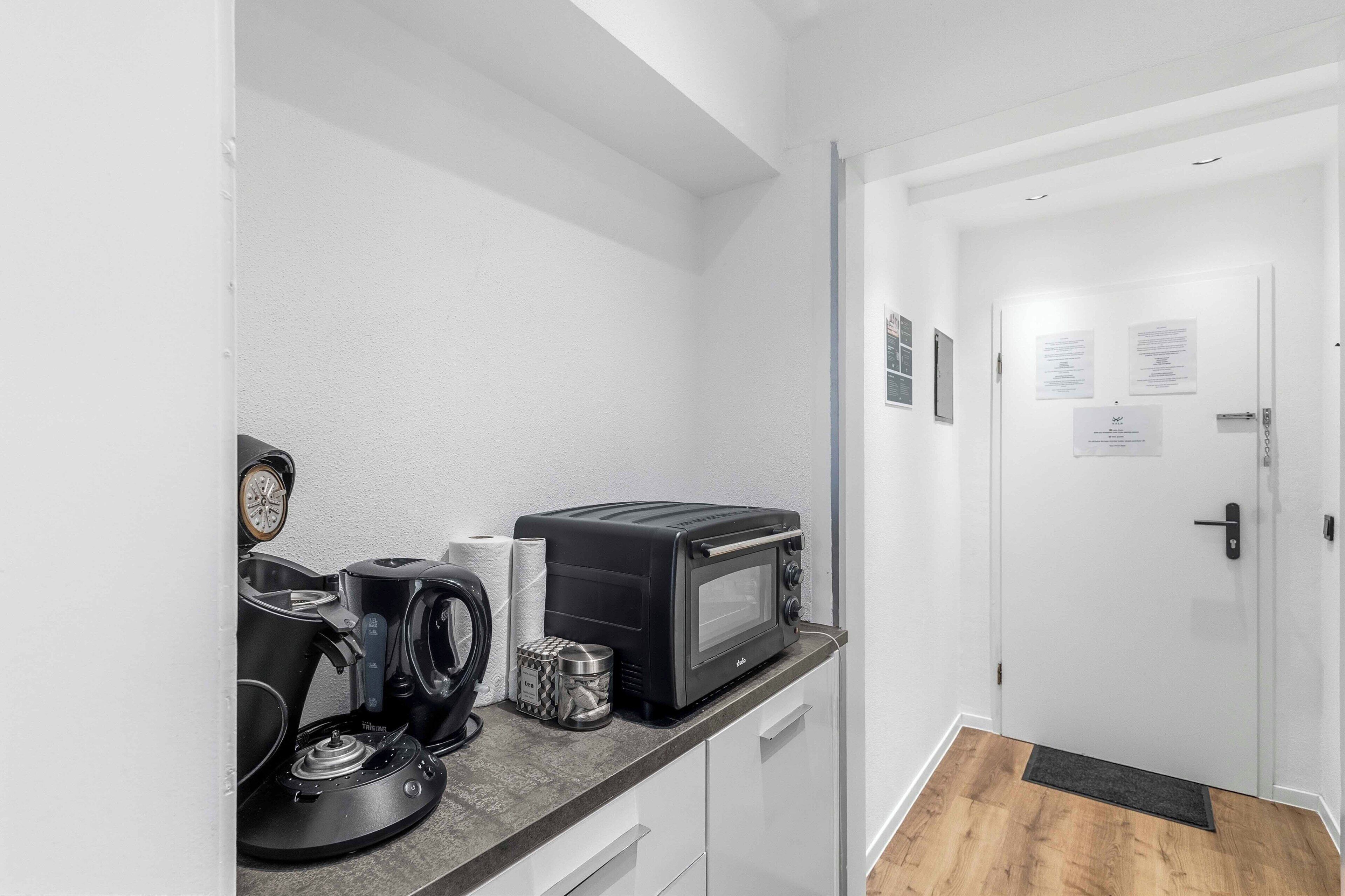 Eine Küchenzeile mit Kaffeemaschine, Toaster und Wasserkocher.