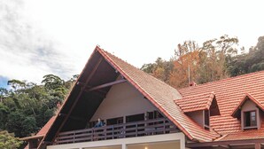 Un bâtiment doté d’un toit en pente, d’un balcon et d’un espace d’accueil.