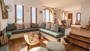A spacious living area with a green sofa, wooden coffee table, and a view of the outdoors. - Villa Levante Montiboli by Buccara (Villajoyosa)