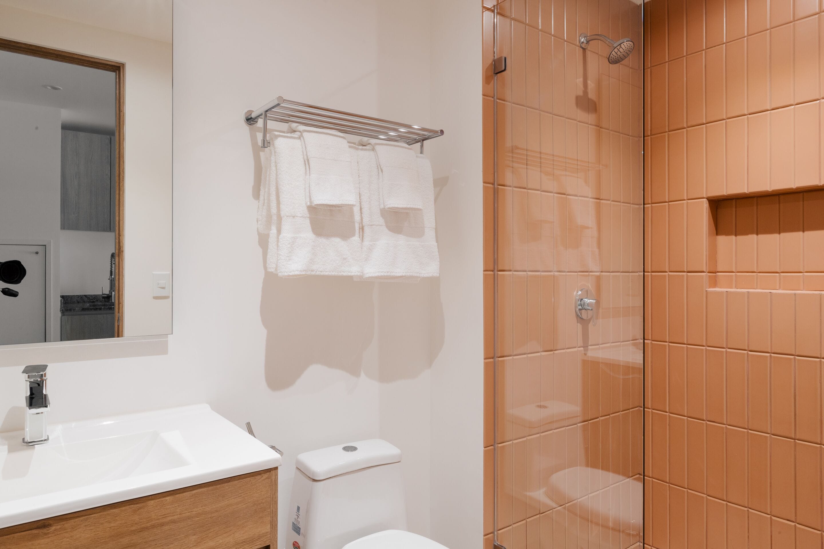 A bathroom with a white sink, a toilet, and a glass shower enclosure.