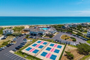 A coastal residential area with a beach, a swimming pool, and a parking lot.