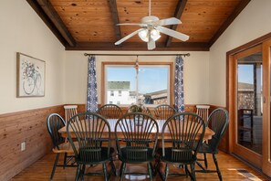 A dining area with a wooden table, chairs, and a ceiling fan.