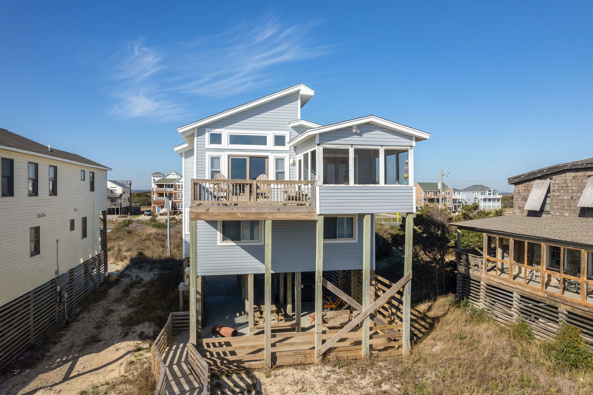 A two-story house with a balcony, a deck, and a staircase leading to the upper floor.