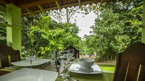 Mesa preparada para comer con vista a exuberante follaje.