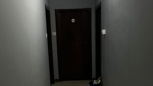 A narrow hallway with a tiled floor, a door marked with the number 305, and a blue trash bin. - iROOMZ Hotel Shree Jagannath (Hyderabad)