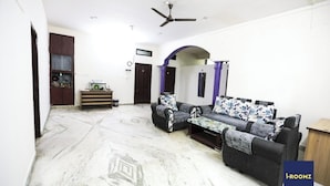 A living room with a sofa set, a ceiling fan, and a marble floor. - iROOMZ Hotel Shree Jagannath (Hyderabad)