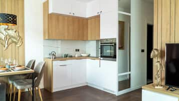 Een minikoelkast, een oven, een kinderstoel, kookgerei, borden en bestek
