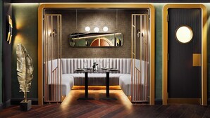 Een modern interieur met een zithoek, een tafel en een decoratief bladerkunstwerk.