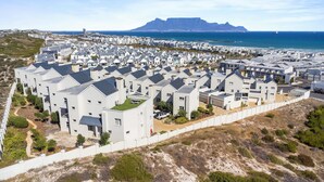 A residential area with modern houses, a sandy landscape, and a distant mountain. - Bona View G36 (Cape Town)