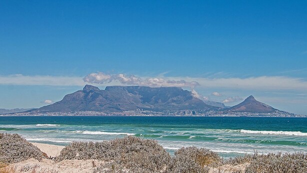 A coastal landscape with mountains in the background and a beach in the foreground. - Bona View G36 (Cape Town)