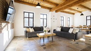 A spacious living room with two dark sofas, a wooden coffee table, and large windows. - Rudnik Krc070 in Rudn k (Rudník)