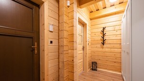A wooden interior with a door, a wall-mounted light fixture, and a small black object on the floor. - Velk Karlovice Mkr545 (Velké Karlovice)